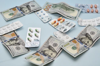 a pile of pills and money sitting on top of a table