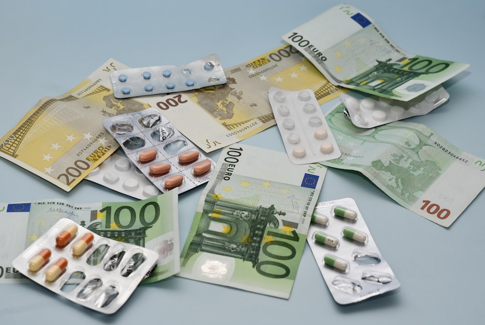 a pile of pills and money sitting on top of a table