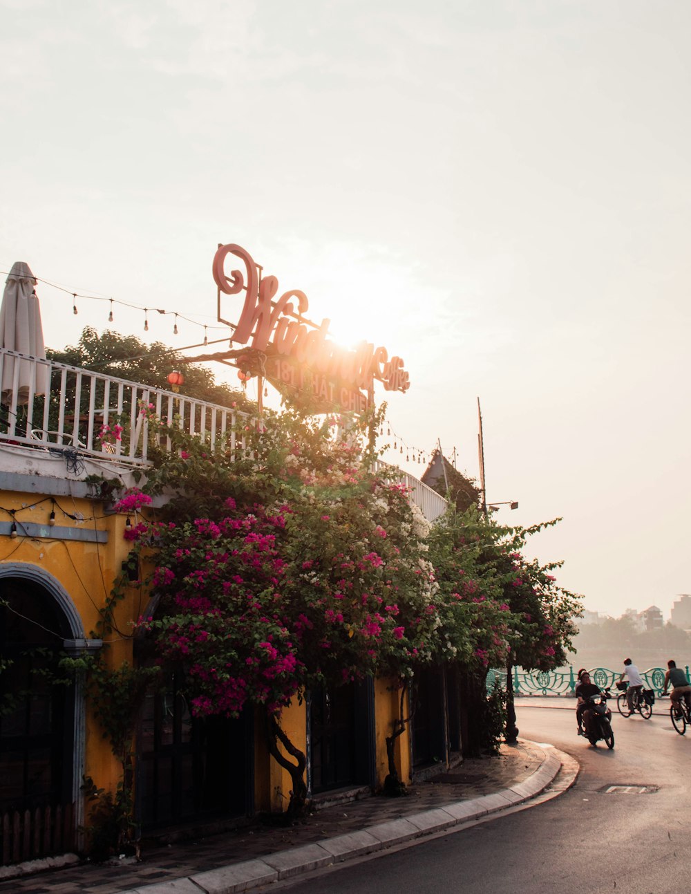 a yellow building with flowers growing on it