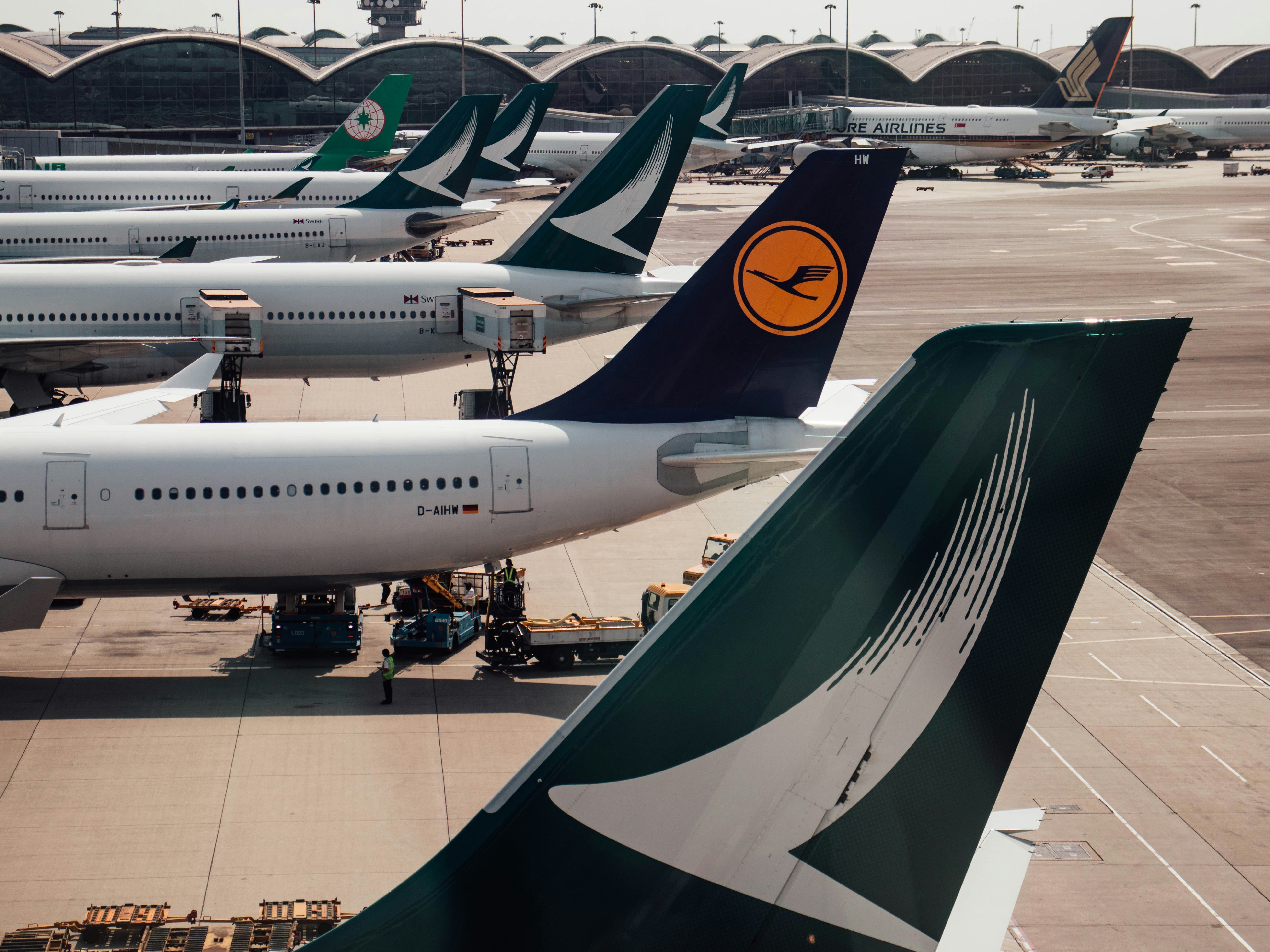 a group of airplanes parked at an airport, Hong Kong International Airport, Cathay Pacific, Lufthansa