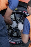 two men working on a tire on a car