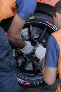 two men working on a tire on a car