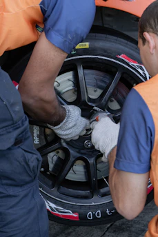 two men working on a tire on a car