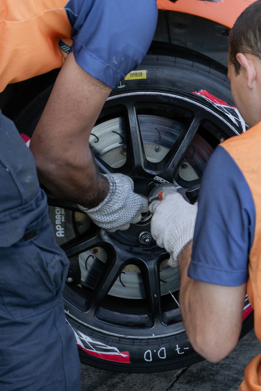 zwei männer, die an einem reifen an einem auto arbeiten