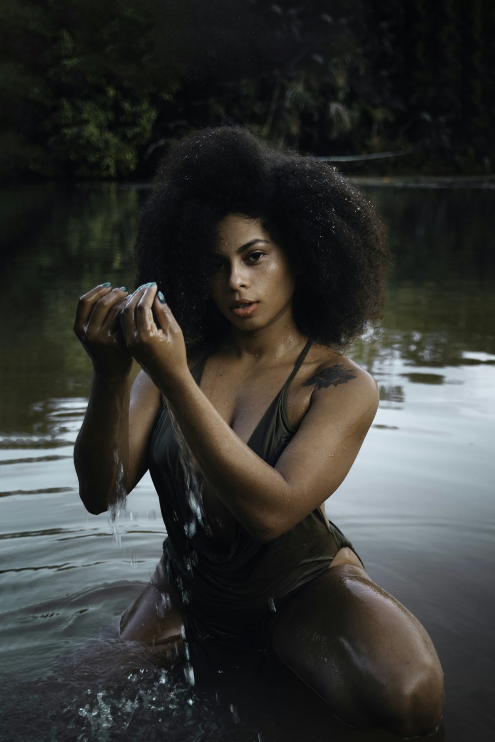 a woman in a body of water holding a cell phone