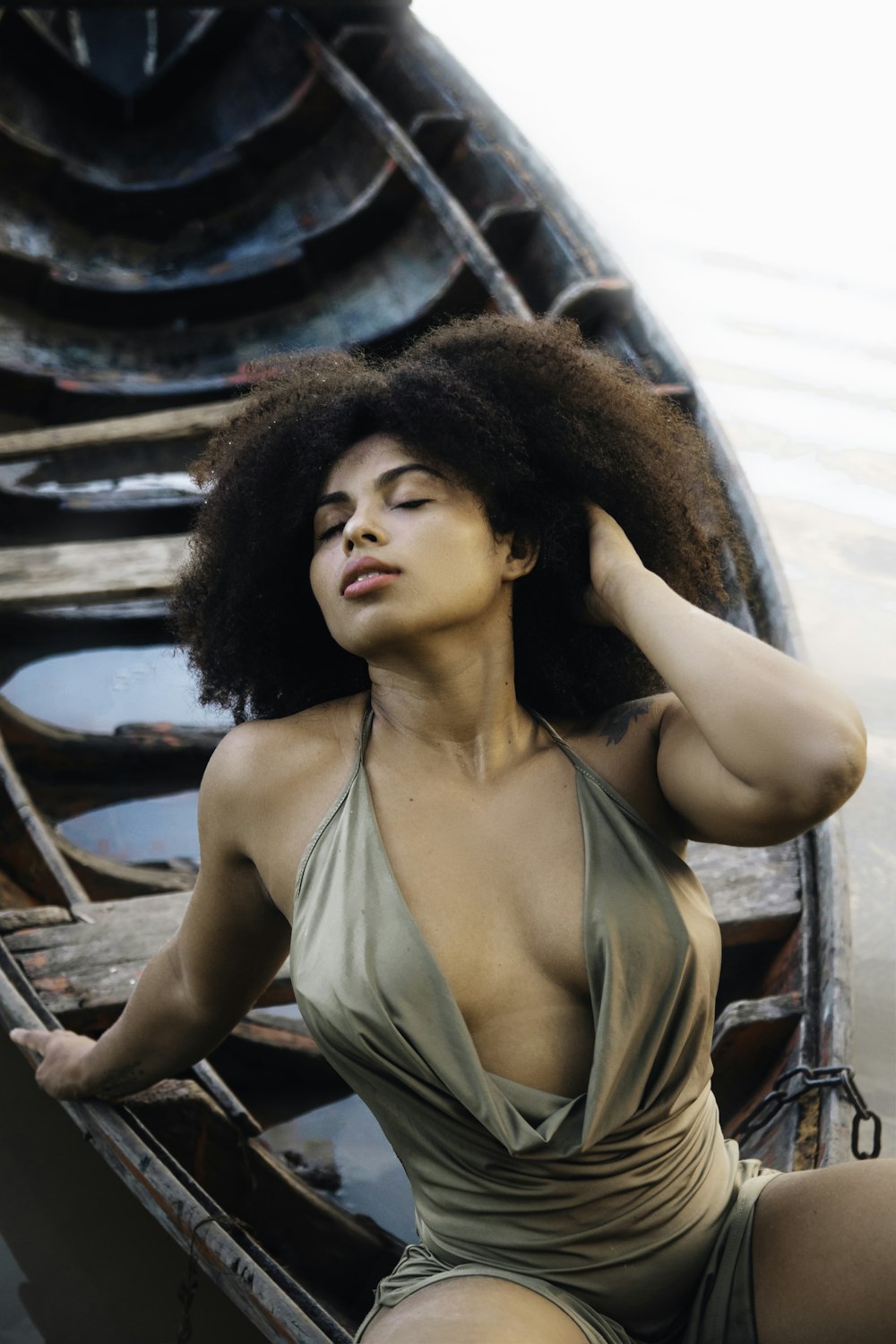 a woman in a bodysuit sitting on a boat