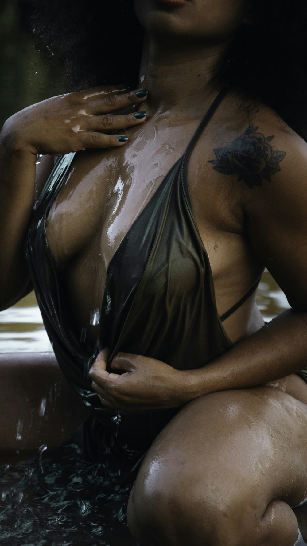 a woman in a bathing suit sitting in a pool of water