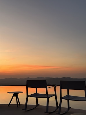 A patio rocking chair gently swaying with a soft breeze under a shaded pergola.