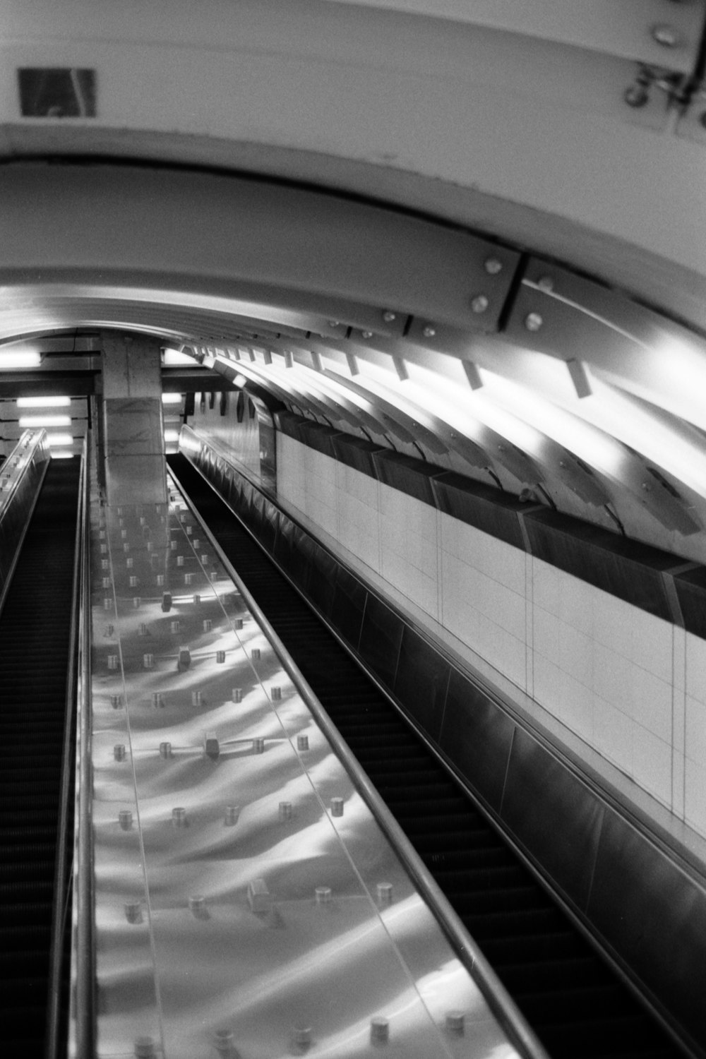 a black and white photo of an escalator