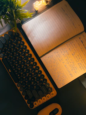 Warm-toned workspace with a cozy lamp and a notebook open for writing.