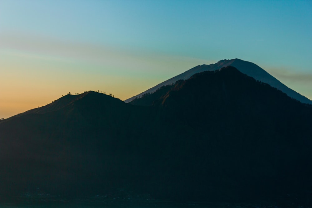 the sun is setting behind a mountain range