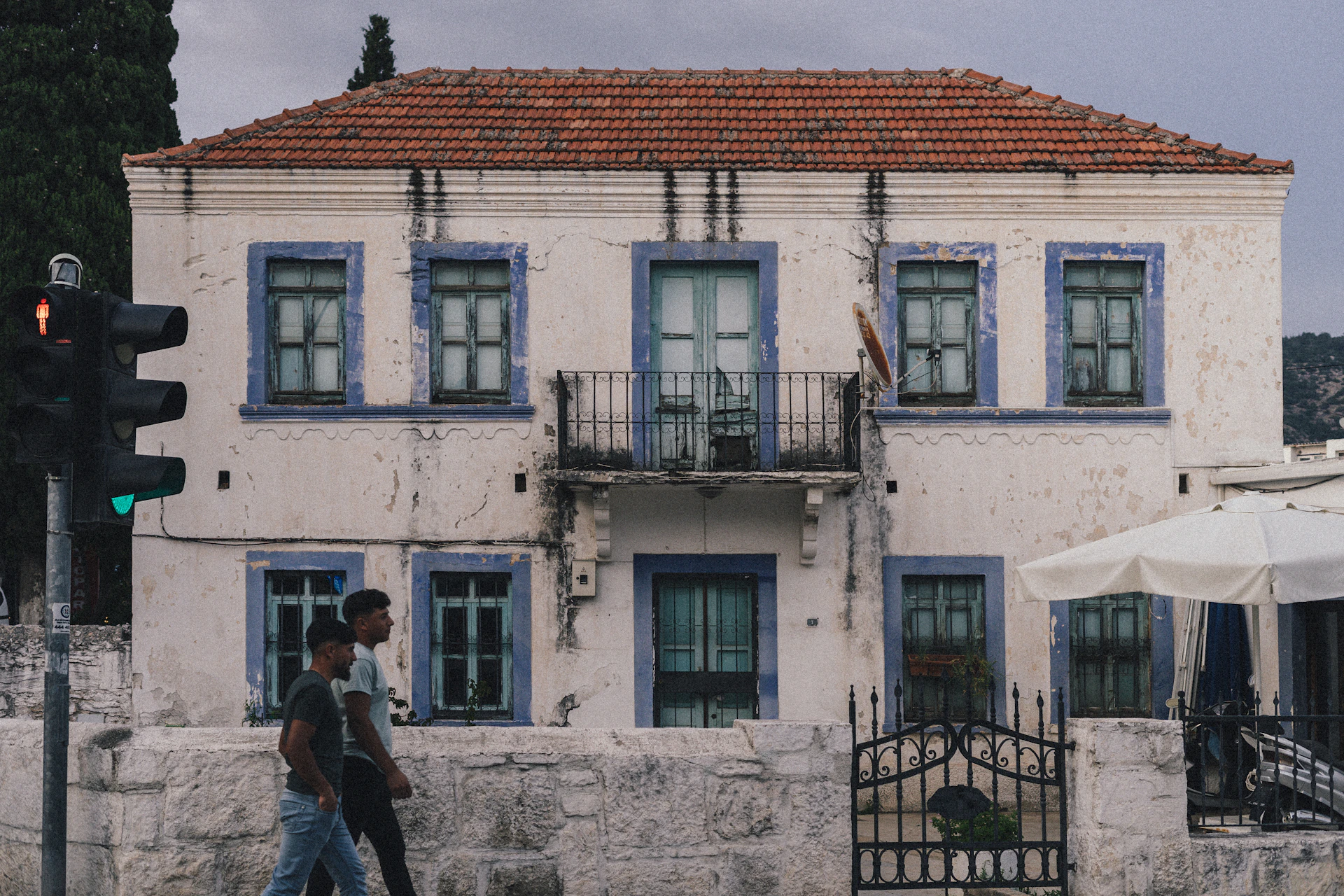 a man walking across a street next to a tall building