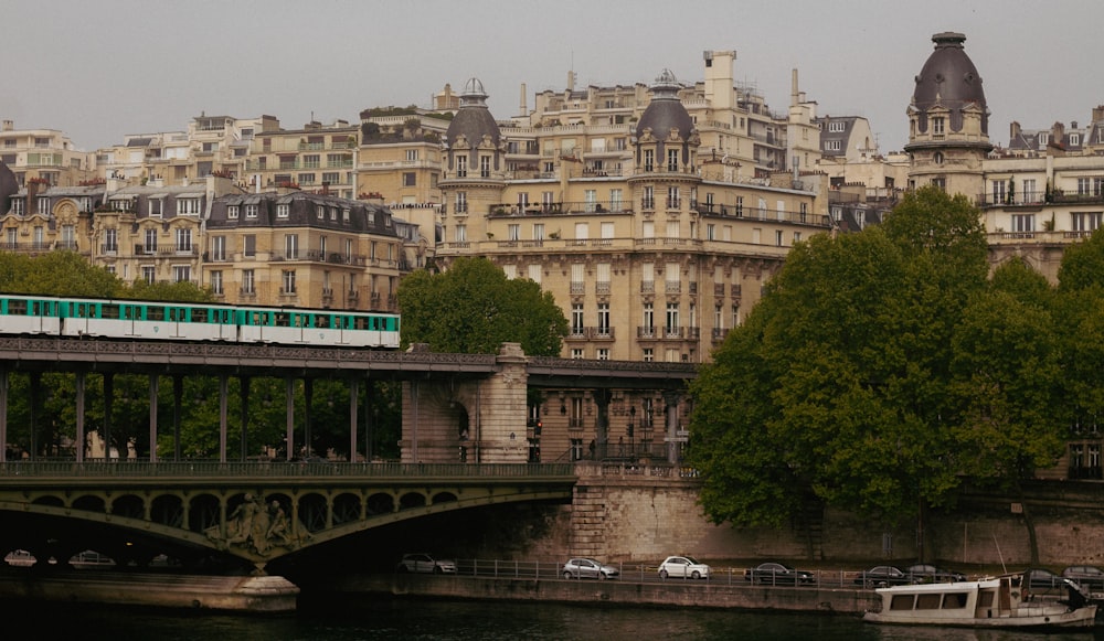 a green and white train traveling over a bridge