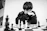 A young boy concentrating deeply on a chessboard during an online coaching session.