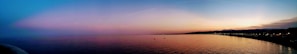A panoramic view of the Somali coastline at sunset, with gentle waves and golden light reflecting on the water