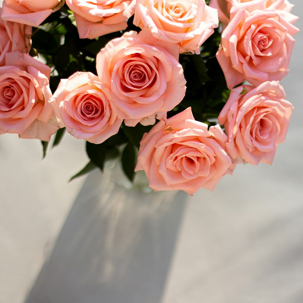 a vase filled with pink roses on top of a table