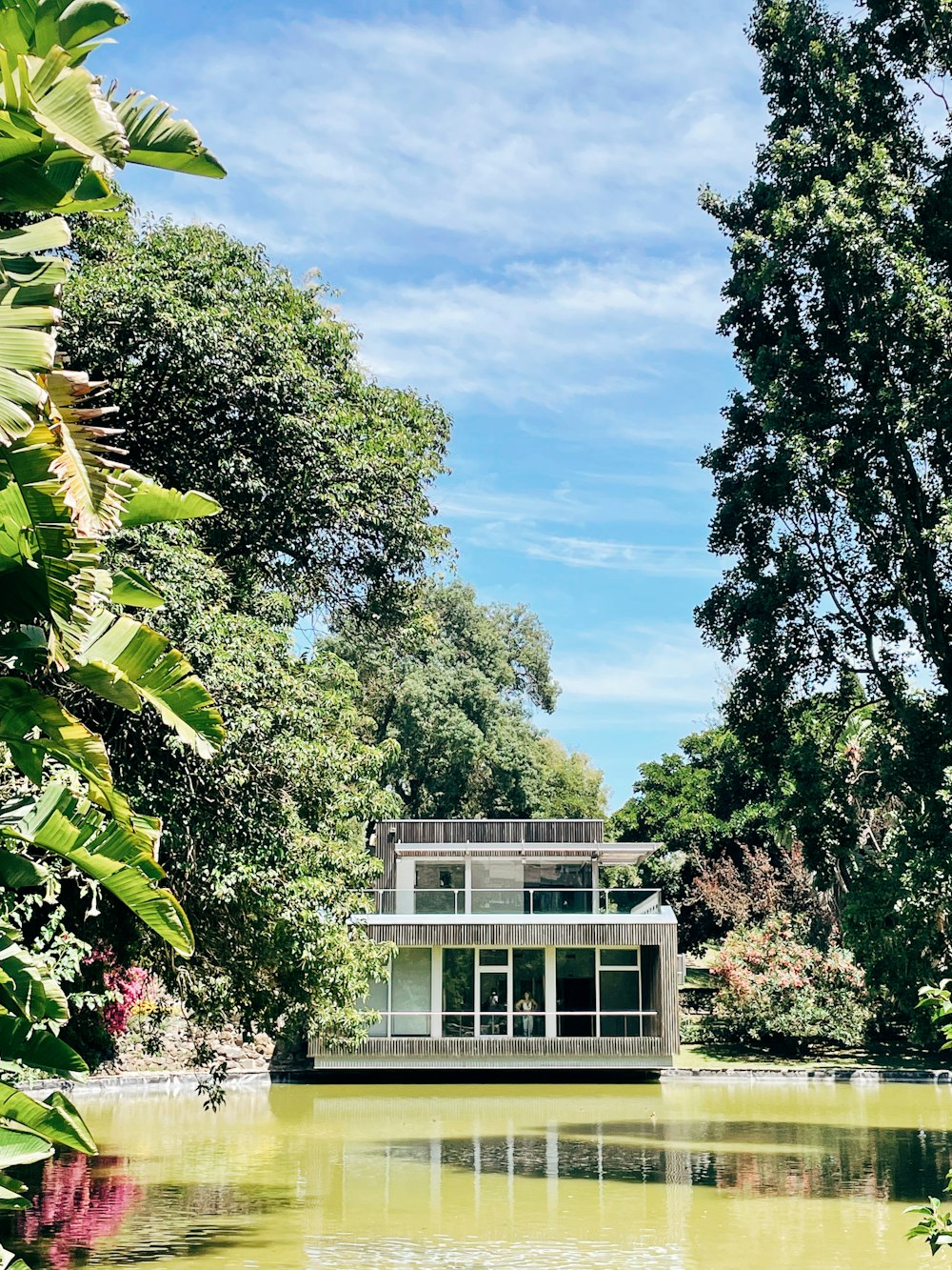 a house on a lake surrounded by trees