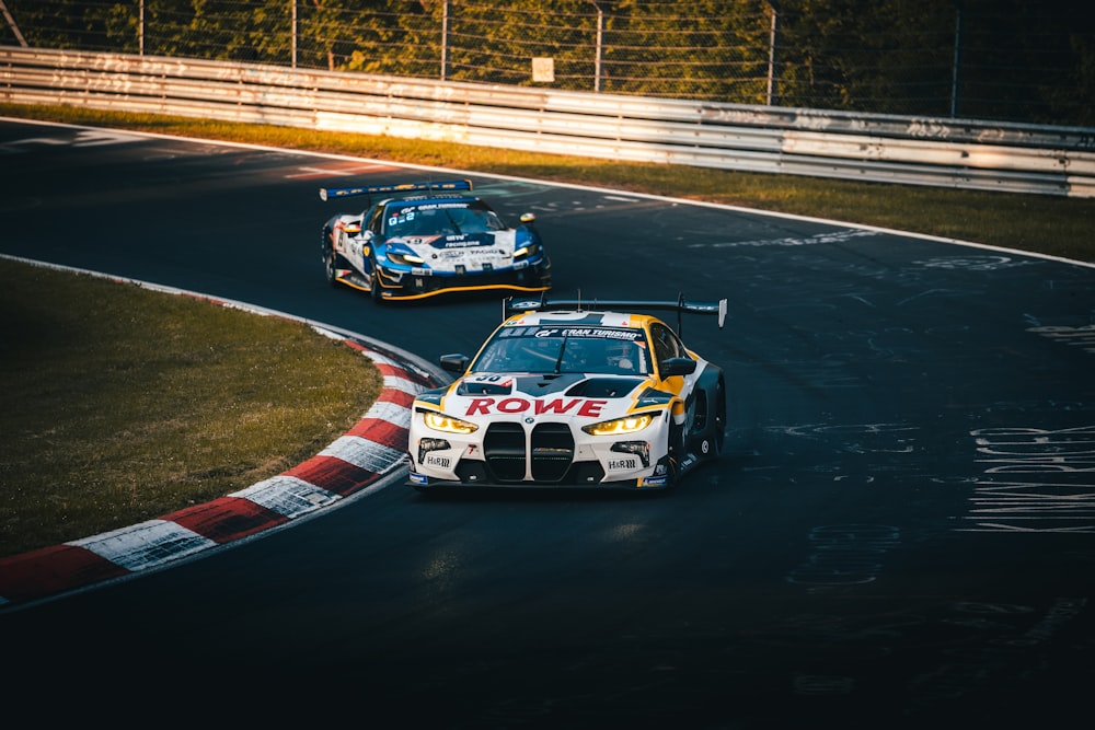 a couple of cars driving down a race track