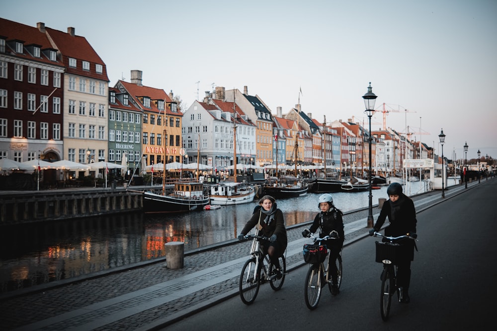 a group of people riding bikes down a street