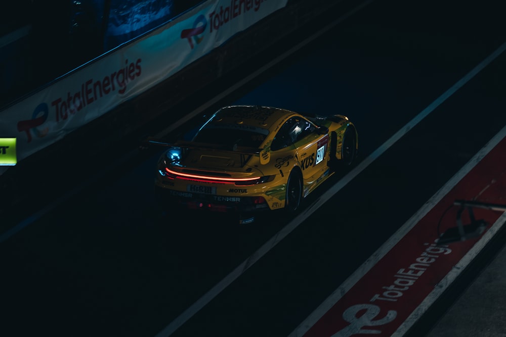 a yellow sports car driving down a race track