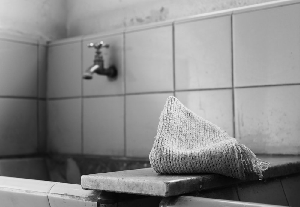 a towel sitting on top of a bath tub next to a faucet