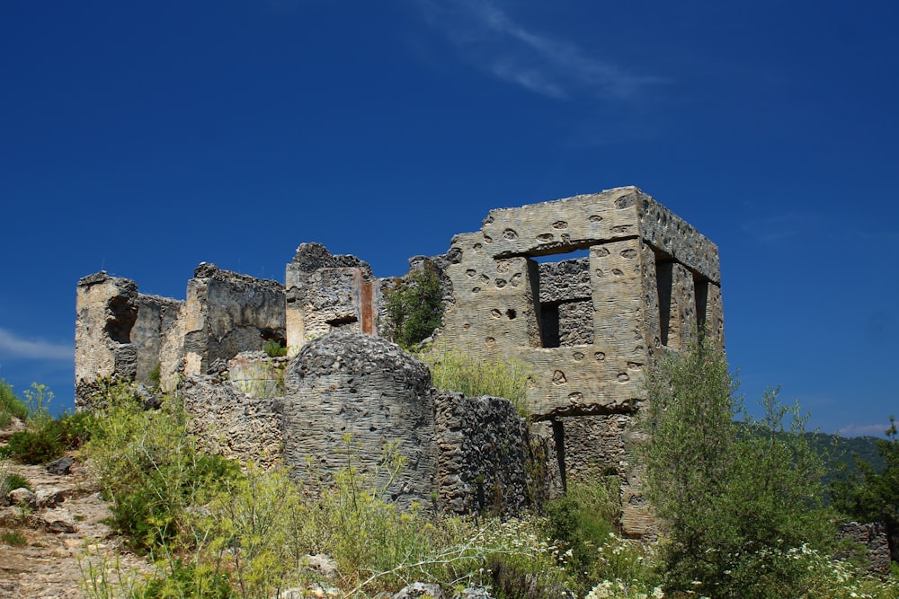 an old stone building sitting on top of a hill