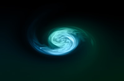 A swirling pattern of colors creates an abstract vortex on a dark background. The center features lighter shades transitioning to darker hues as they spiral outward.
