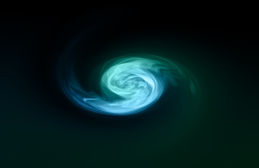a green and blue swirl in the dark