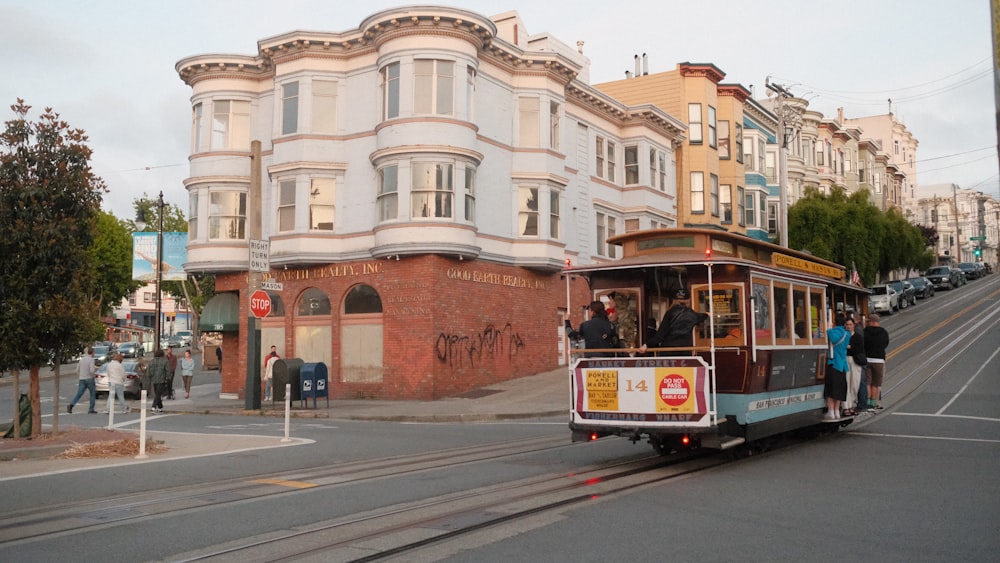 a cable car traveling down a street next to a tall building