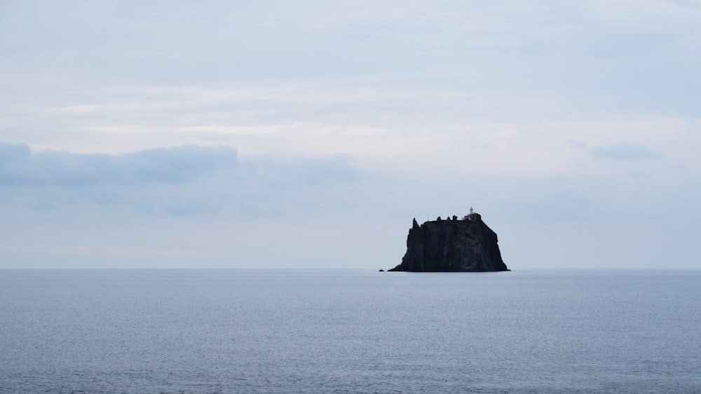 a large rock out in the middle of the ocean