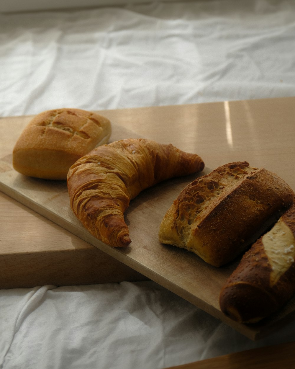 un paio di croissant seduti sopra un tagliere di legno