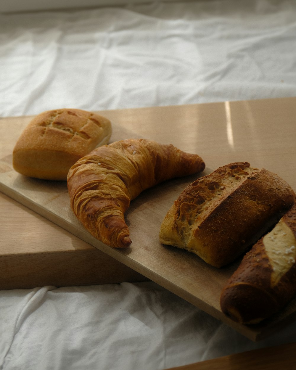 a couple of croissants sitting on top of a wooden cutting board