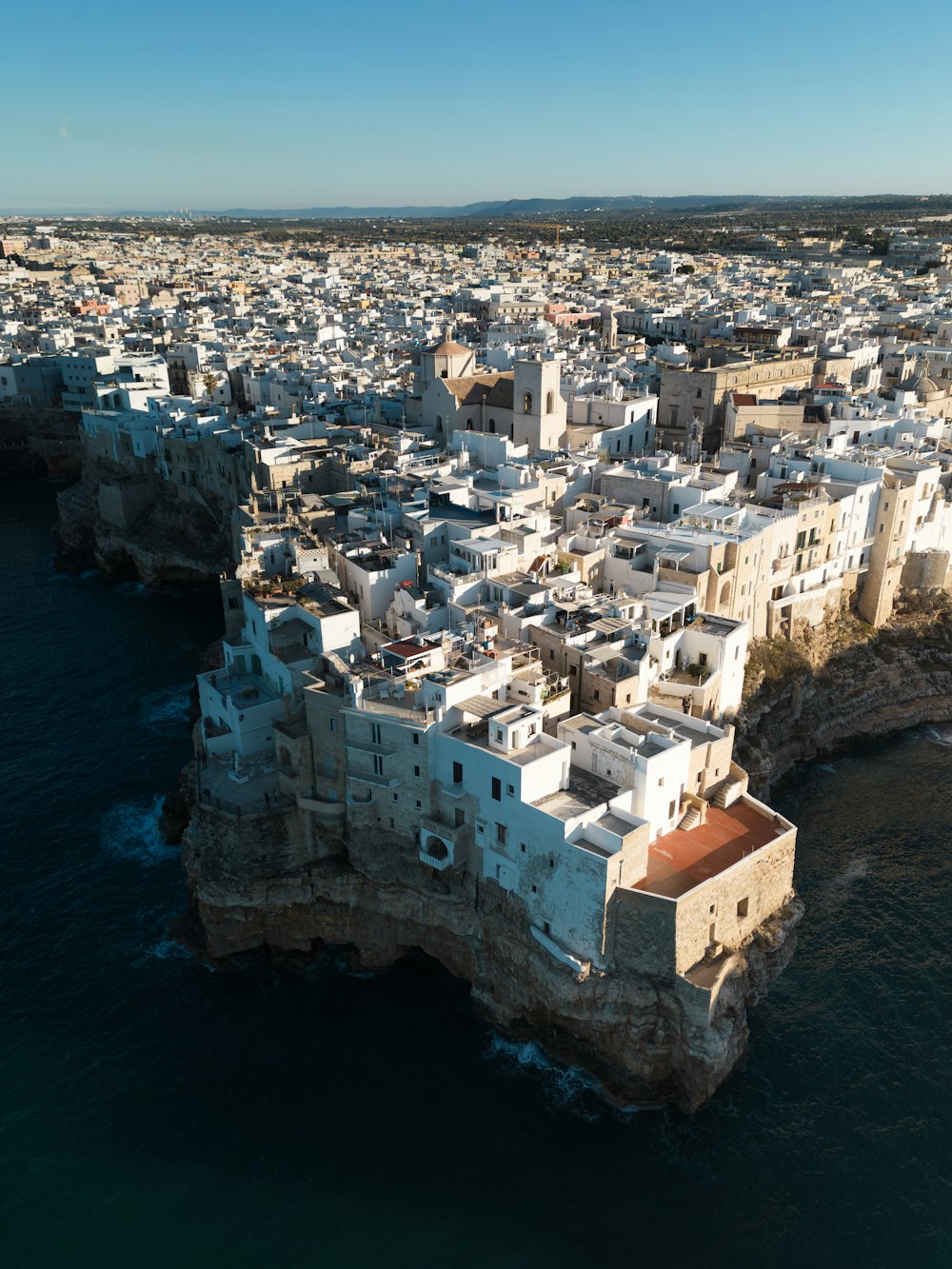 uma vista aérea de uma cidade na costa de um corpo de água