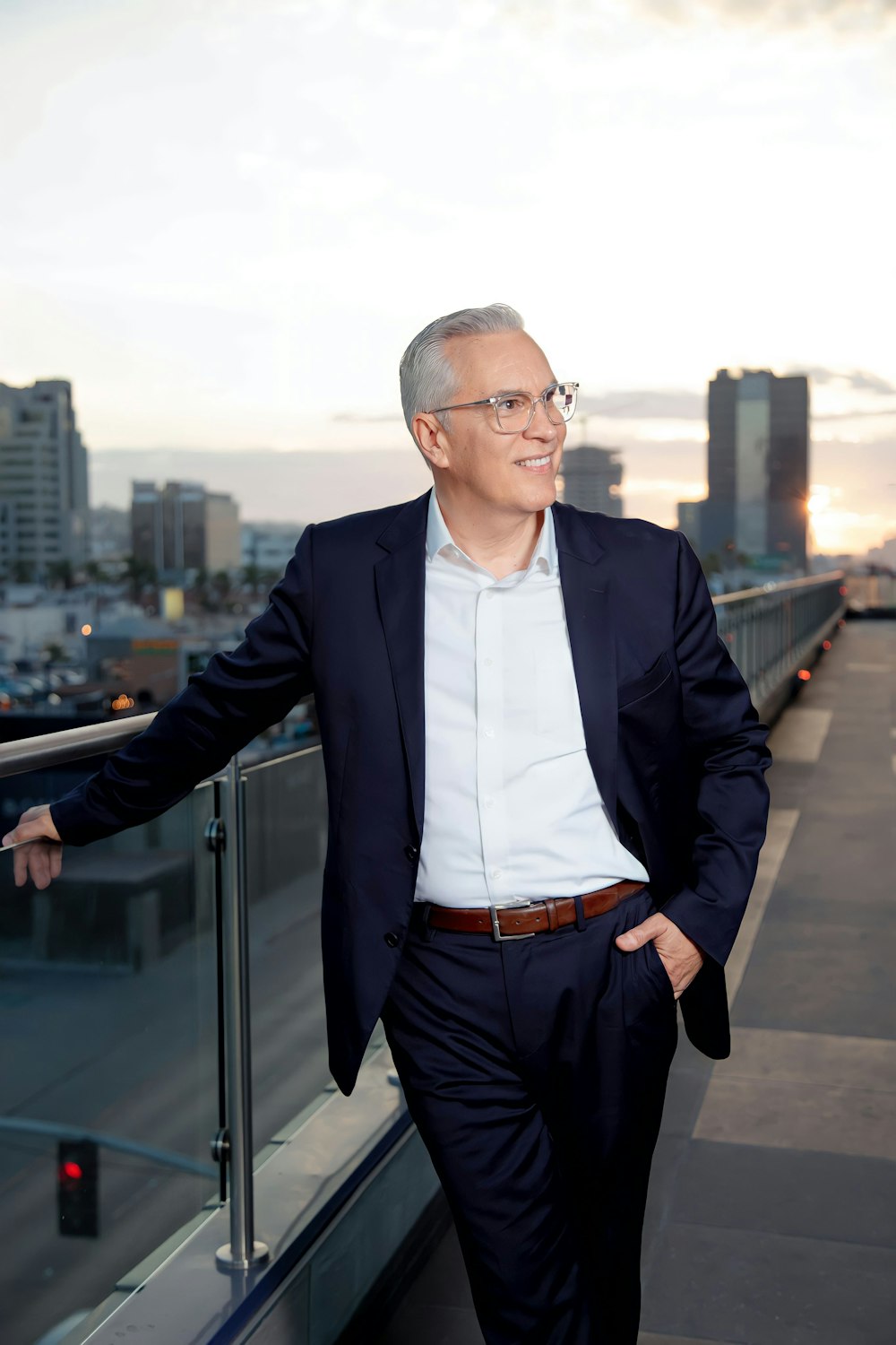 a man in a suit leaning on a railing