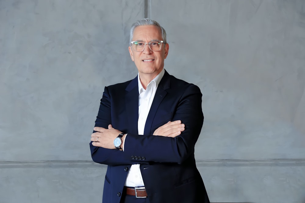 a man in a suit standing with his arms crossed