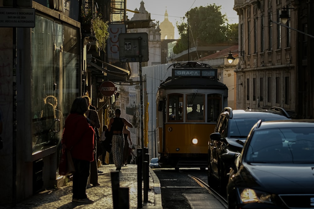 a yellow trolley car on a city street