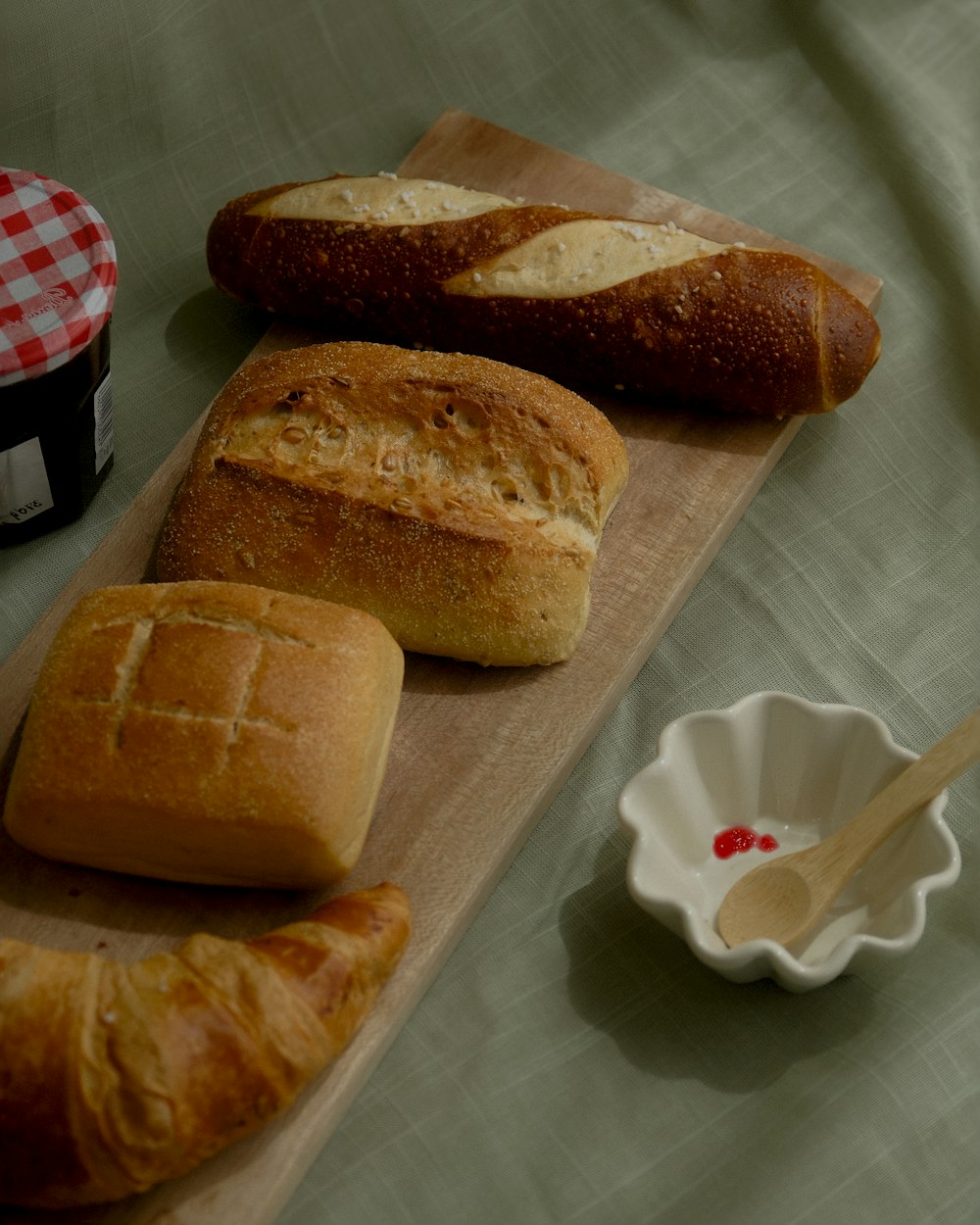 a table topped with bread and a bowl of jelly