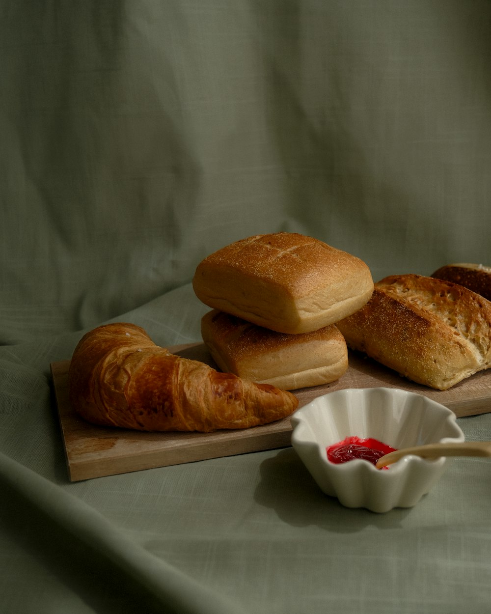 a wooden board topped with loaves of bread