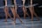 Ballet dancers in tutus are poised on stage, demonstrating graceful movements and coordination. The focus is on their legs, showing strength and elegance, as they balance on pointe shoes.