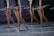 Ballet dancers in tutus are poised on stage, demonstrating graceful movements and coordination. The focus is on their legs, showing strength and elegance, as they balance on pointe shoes.