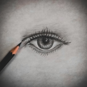 A close-up of a detailed pencil portrait in progress, showcasing fine shading and texture.
