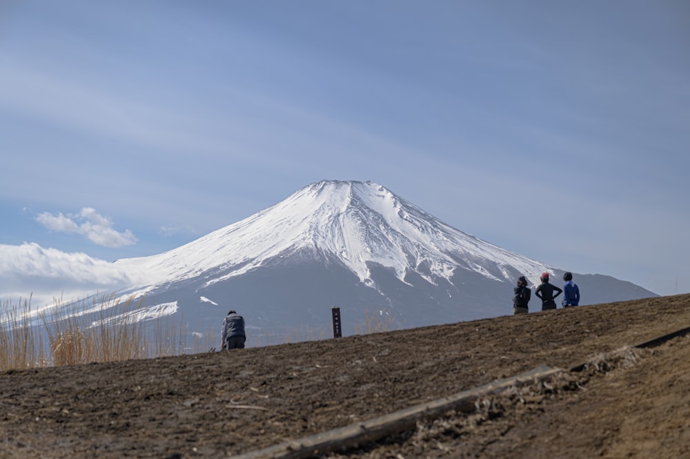 a group of people standing on top of a dirt hill
