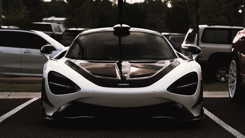 a white and black sports car parked in a parking lot