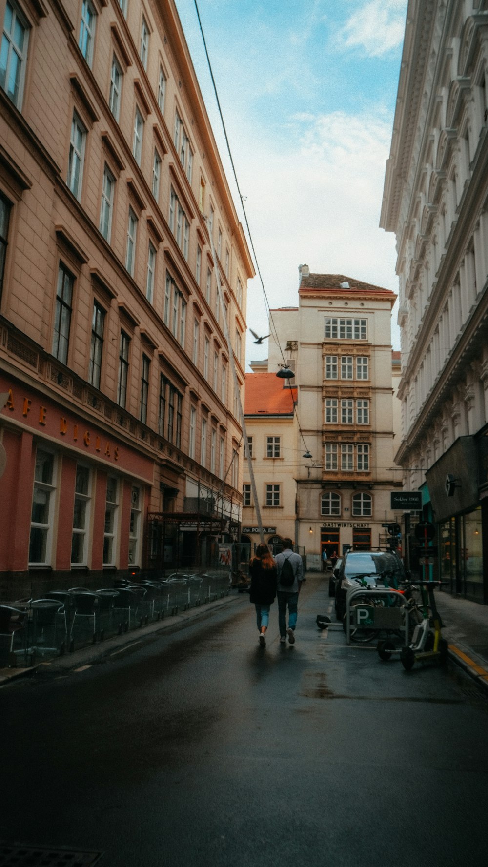 a group of people walking down a street next to tall buildings