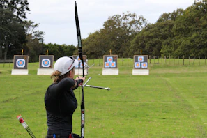 Wide shot of the shooting club with targets lined up and students practicing