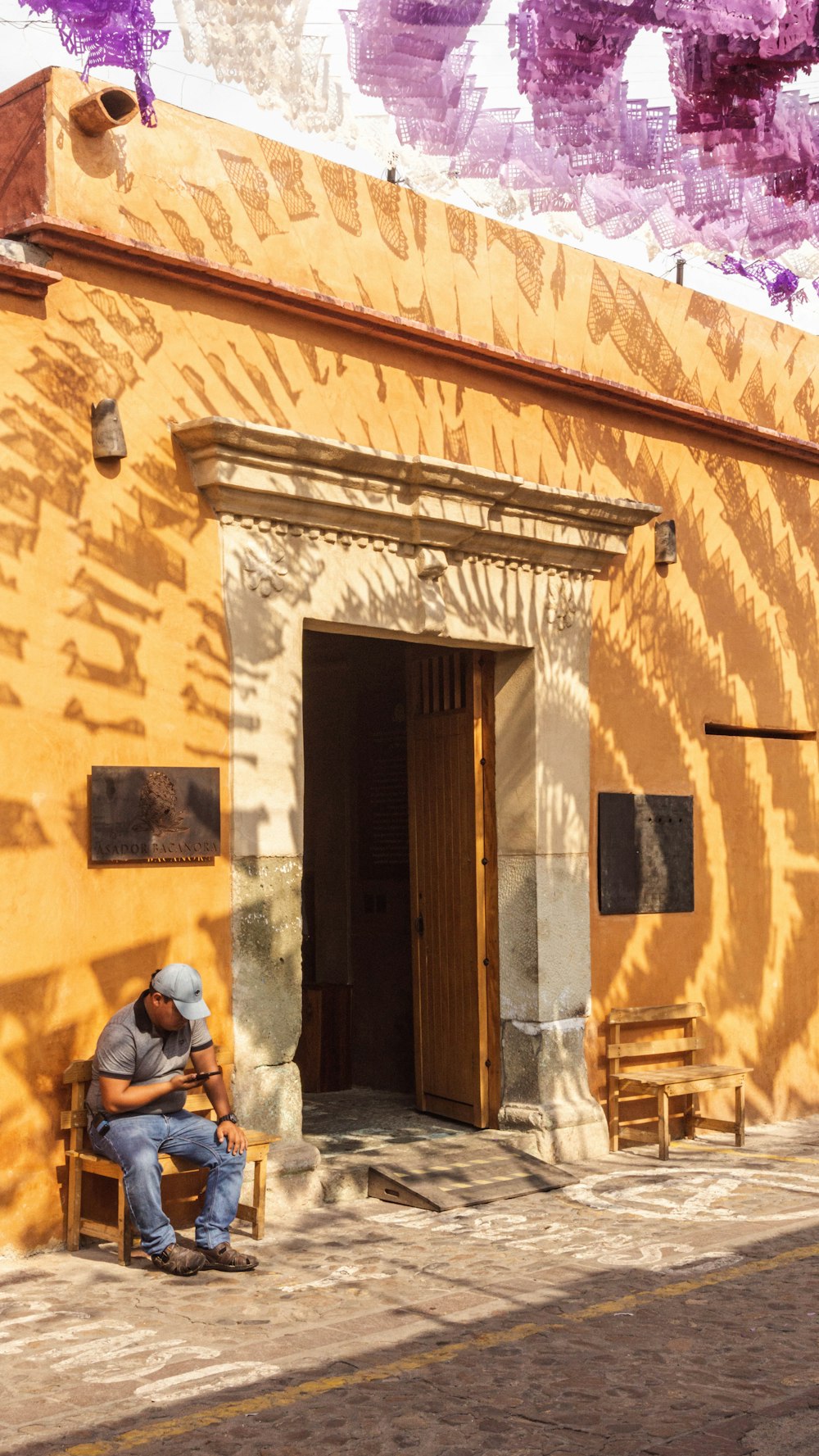 a man sitting on a bench in front of a building