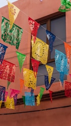 a bunch of colorful flags hanging from a building