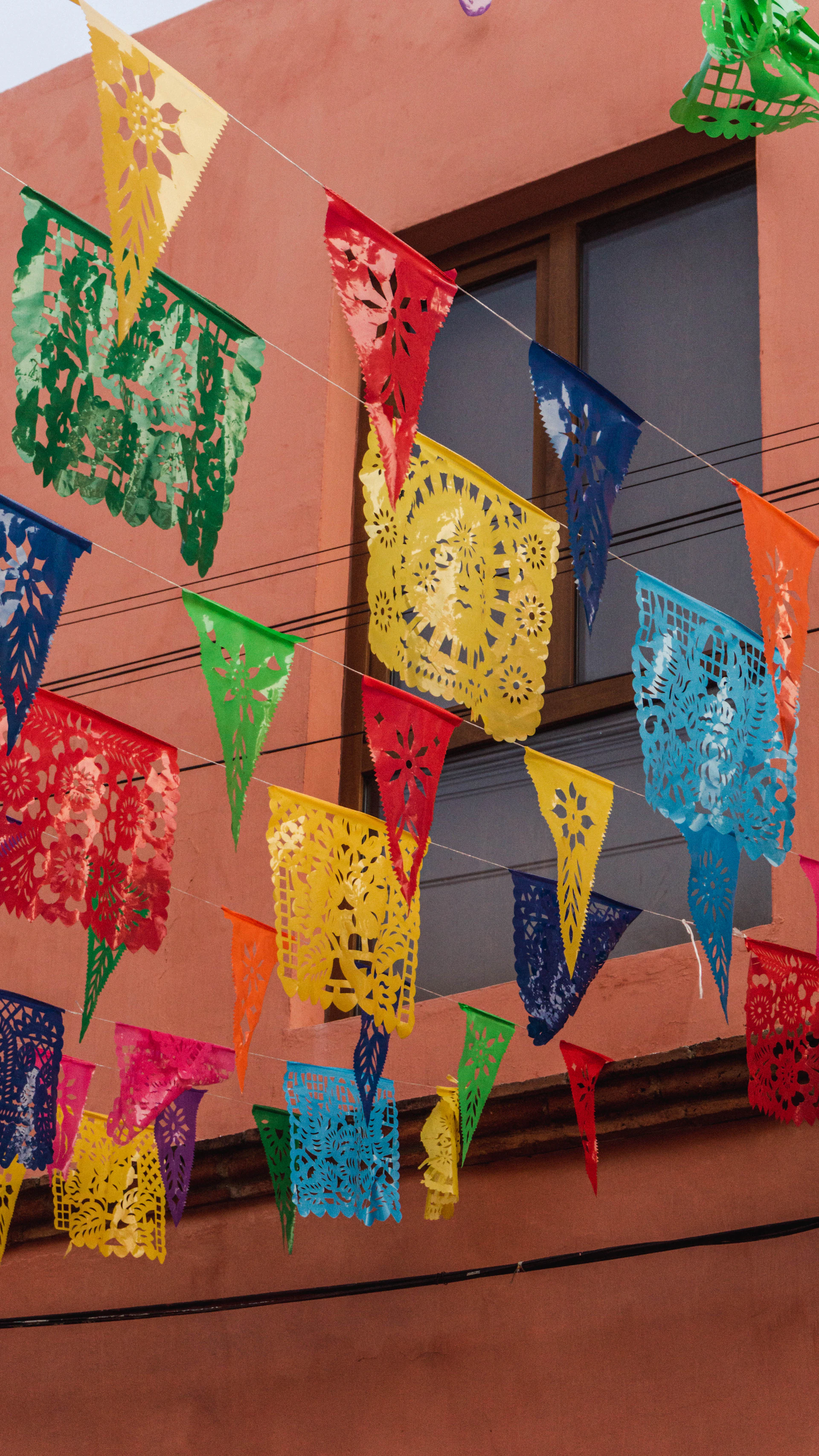 a bunch of colorful flags hanging from a building