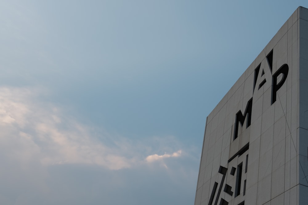 a tall white building with a sky in the background