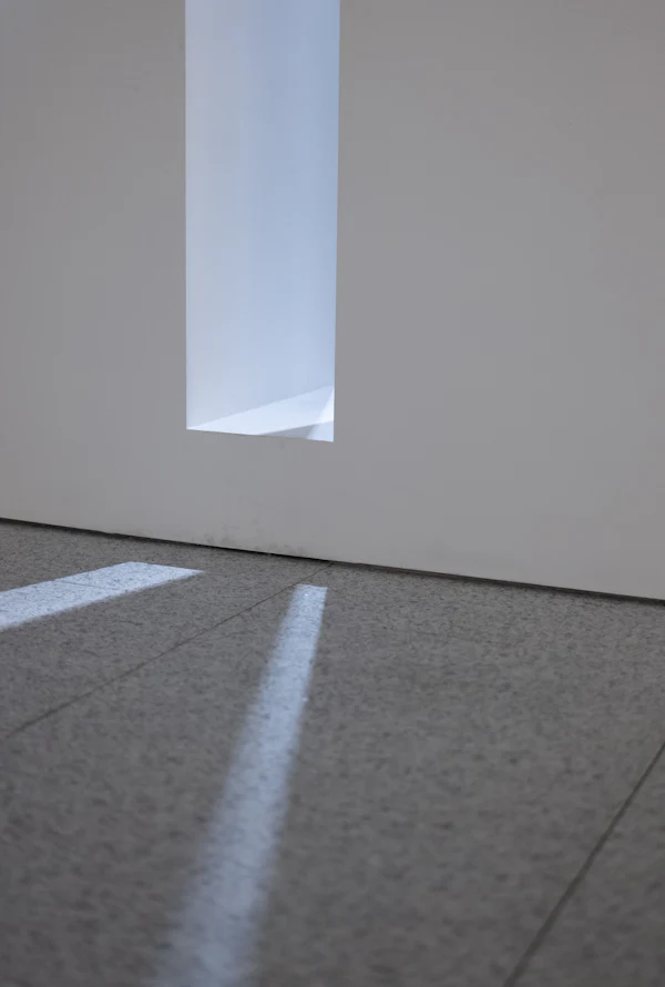 Light from a window falling across the floor of a quiet, empty room